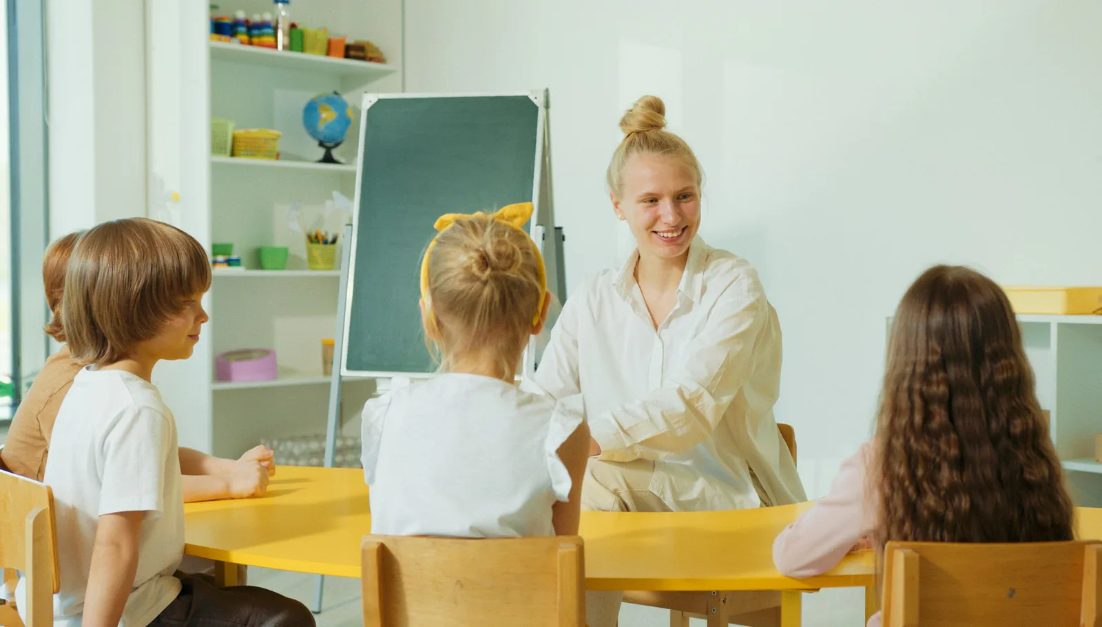 Teacher engaged with children in a warm classroom setting